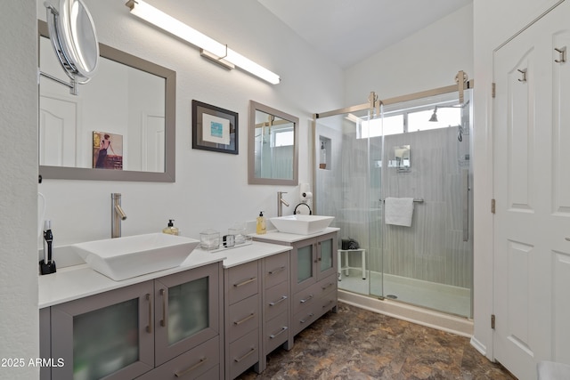 bathroom featuring a sink, double vanity, and a stall shower