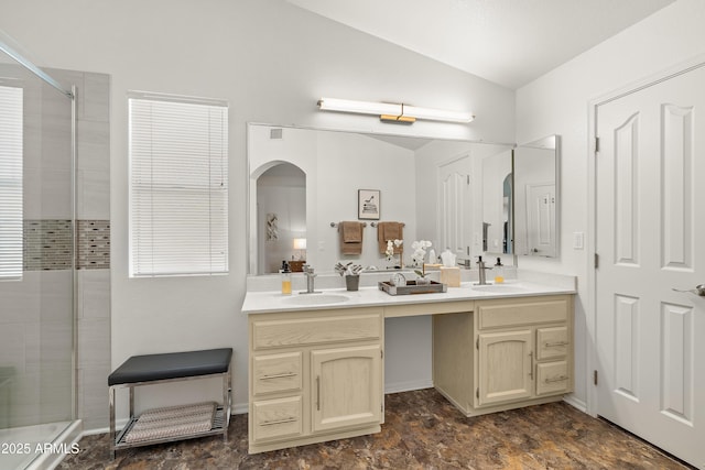 bathroom featuring vaulted ceiling, a sink, and double vanity