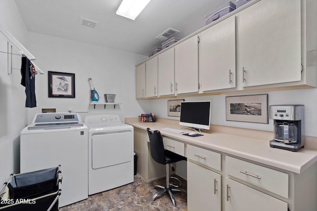washroom with visible vents, washer and clothes dryer, stone finish flooring, and cabinet space