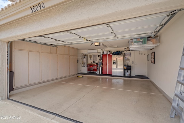 garage with water heater, stainless steel refrigerator with ice dispenser, and a garage door opener