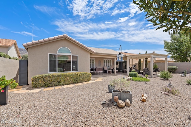 back of house with a pergola, a tiled roof, stucco siding, and fence