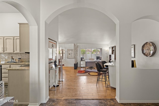 hall with baseboards and wood finished floors