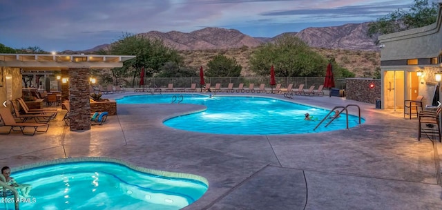 community pool featuring a pergola, a patio, fence, and a mountain view
