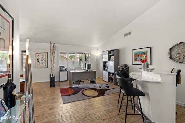 interior space featuring baseboards, wood finished floors, visible vents, and high vaulted ceiling
