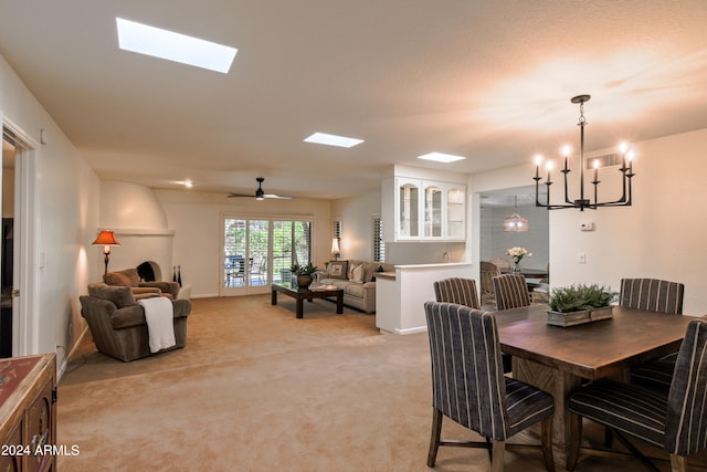 carpeted dining room featuring ceiling fan with notable chandelier