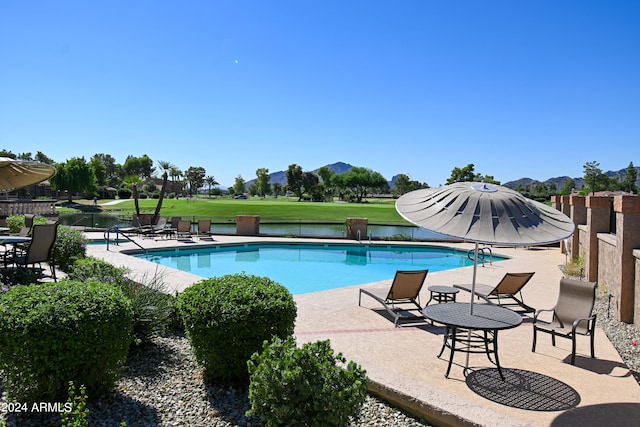 view of swimming pool with a mountain view and a patio area