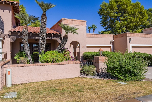 mediterranean / spanish-style house with a front yard