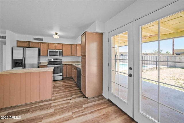 724 N Pine St, Gilbert, AZ 85233 - kitchen featuring stainless steel appliances, light wood finished floors, french doors, and brown cabinetry