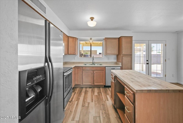 724 N Pine St, Gilbert, AZ 85233 - kitchen featuring stainless steel appliances, a sink, butcher block counters, light wood-type flooring, and french doors