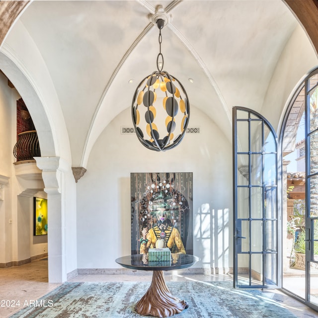 interior space with baseboards, lofted ceiling, arched walkways, and visible vents