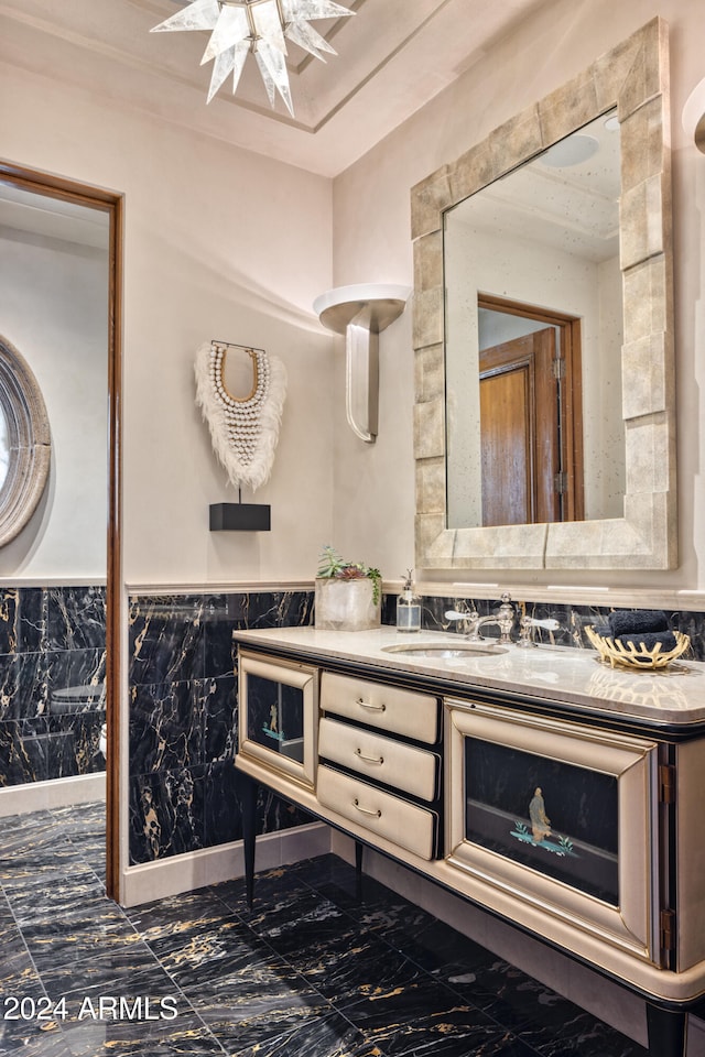 bathroom with vanity, marble finish floor, and wainscoting