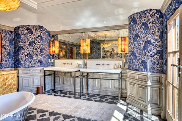 full bath featuring double vanity, a soaking tub, wallpapered walls, and ornamental molding