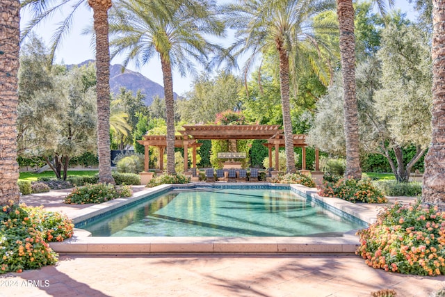 outdoor pool featuring a mountain view, a patio, and a pergola