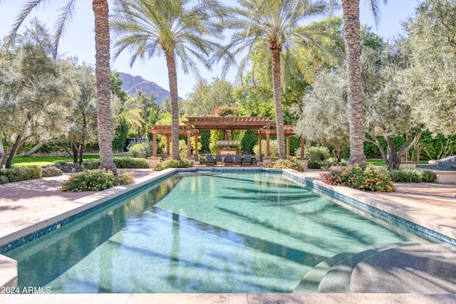 pool featuring a patio area, a mountain view, and a pergola