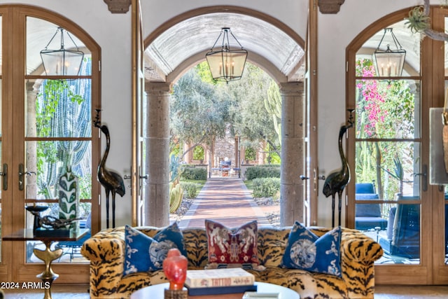 living room with an inviting chandelier, french doors, and arched walkways