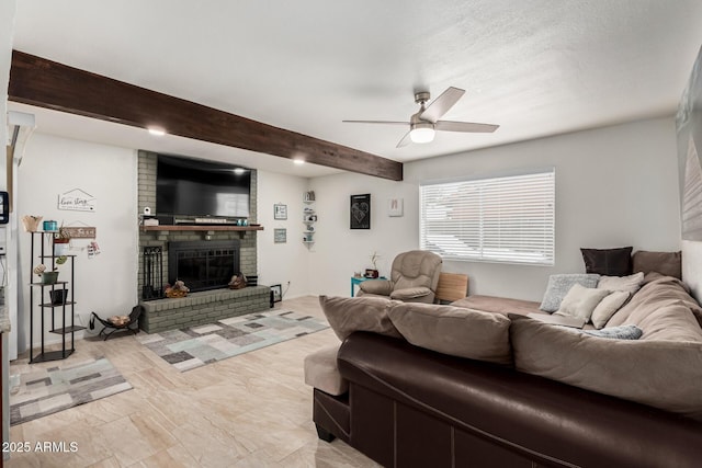 living room with beamed ceiling, a fireplace, and ceiling fan