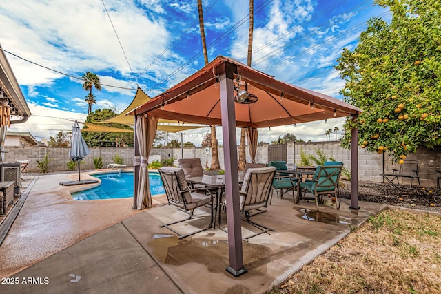 view of patio featuring a gazebo, outdoor dining area, a fenced backyard, and a fenced in pool