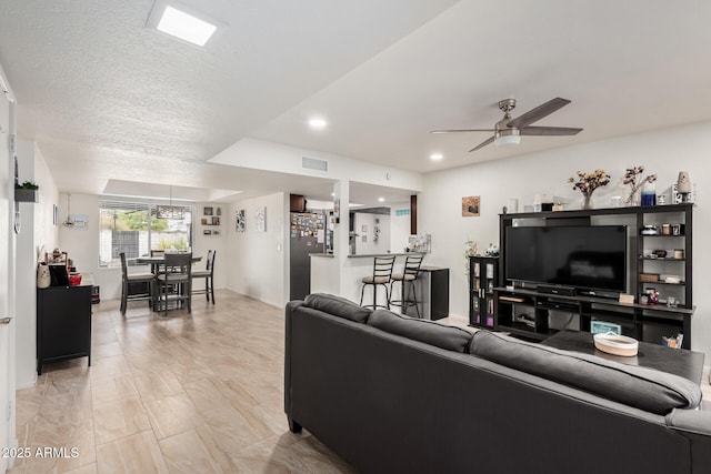 living room with recessed lighting, visible vents, a textured ceiling, and a ceiling fan