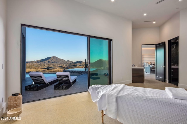 carpeted bedroom with a mountain view and access to exterior