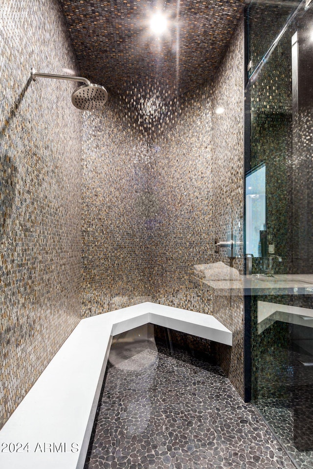 bathroom featuring walk in shower and tile walls