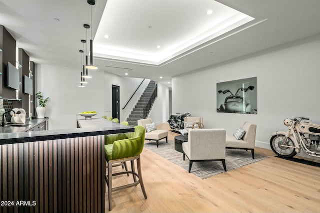 dining room with a tray ceiling, sink, and wood-type flooring