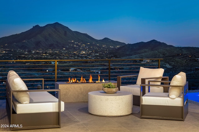 patio terrace at dusk featuring a mountain view and a balcony