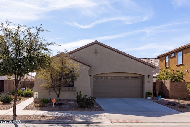 mediterranean / spanish-style home featuring driveway, a garage, fence, and stucco siding