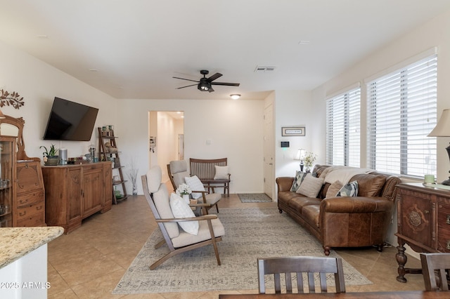 living area featuring light tile patterned floors, ceiling fan, and visible vents