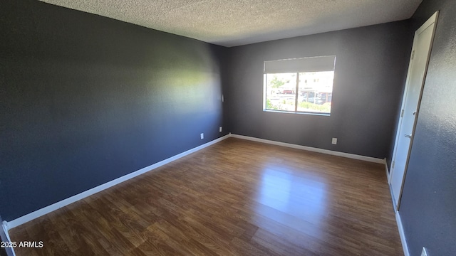 11026 N 28th Dr Unit 34, Phoenix, AZ 85029 - spare room featuring dark wood-type flooring, baseboards, and a textured ceiling