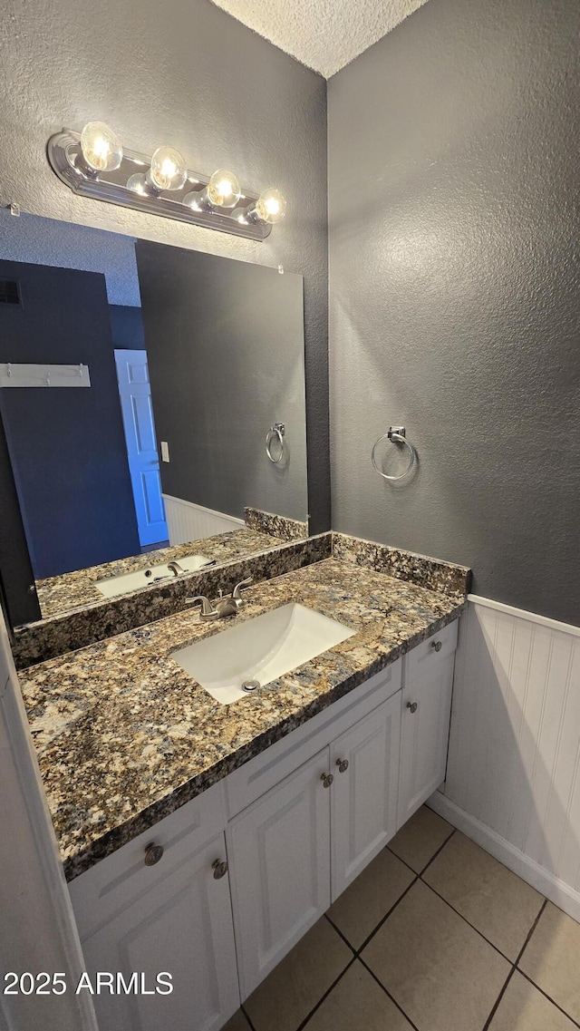 11026 N 28th Dr Unit 34, Phoenix, AZ 85029 - bathroom with tile patterned flooring, vanity, a textured ceiling, a textured wall, and a wainscoted wall