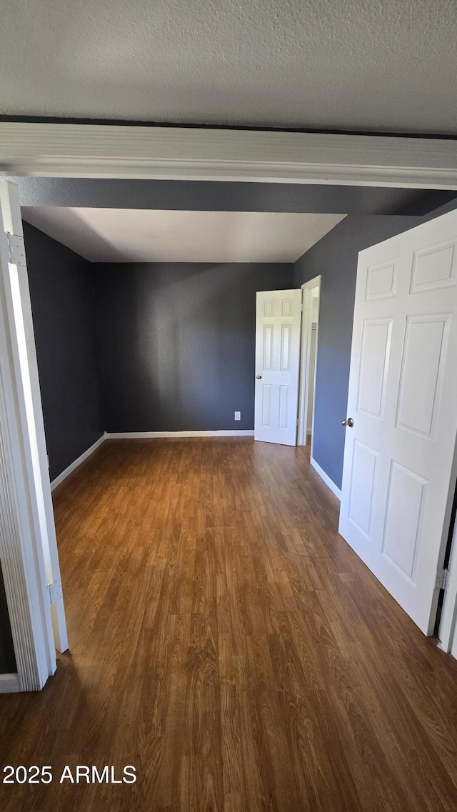 11026 N 28th Dr Unit 34, Phoenix, AZ 85029 - unfurnished room featuring dark wood finished floors, baseboards, and a textured ceiling