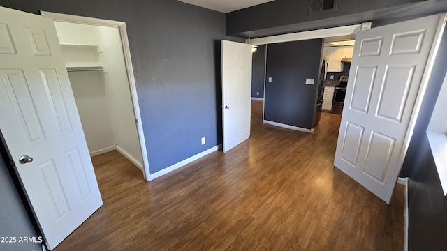 11026 N 28th Dr Unit 34, Phoenix, AZ 85029 - unfurnished bedroom with baseboards, dark wood-type flooring, a closet, and a spacious closet