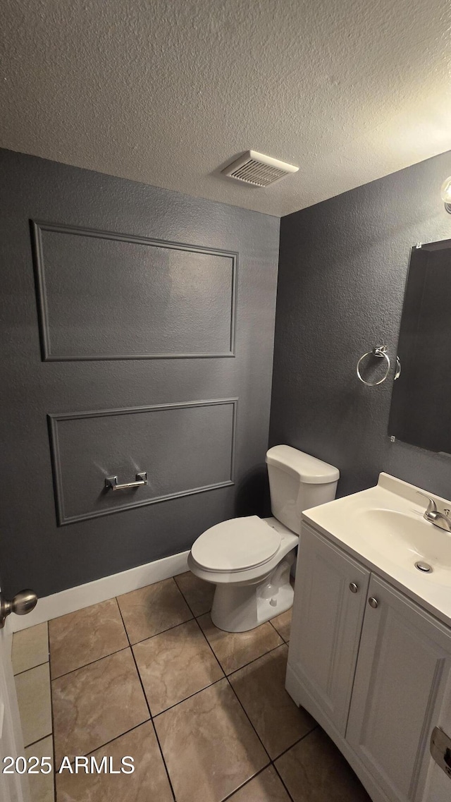11026 N 28th Dr Unit 34, Phoenix, AZ 85029 - bathroom with toilet, vanity, tile patterned floors, a textured ceiling, and a textured wall