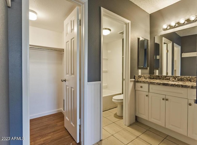 11026 N 28th Dr Unit 34, Phoenix, AZ 85029 - bathroom featuring a textured ceiling, toilet, vanity, tile patterned flooring, and shower / bath combination