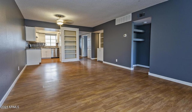 11026 N 28th Dr Unit 34, Phoenix, AZ 85029 - unfurnished living room featuring a textured ceiling, a ceiling fan, dark wood-style floors, baseboards, and built in features