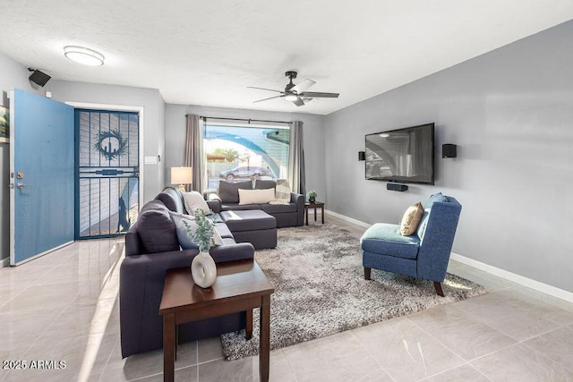 living room featuring a textured ceiling, a ceiling fan, and baseboards