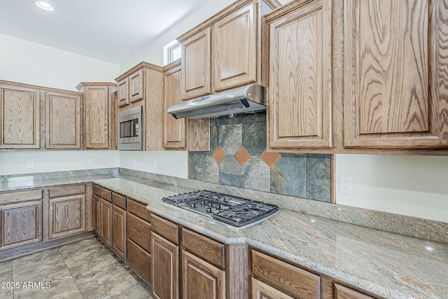 30374 N 124th Dr, Peoria, AZ 85383 - kitchen with under cabinet range hood, appliances with stainless steel finishes, tasteful backsplash, and light stone countertops