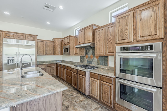 30374 N 124th Dr, Peoria, AZ 85383 - kitchen featuring built in appliances, a sink, light stone counters, under cabinet range hood, and decorative backsplash