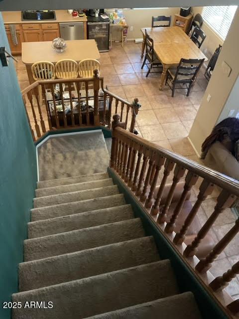 staircase with tile patterned floors and sink