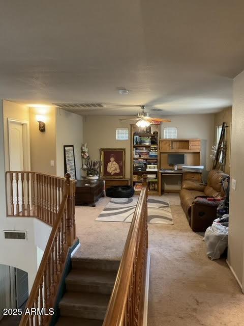 carpeted living room with ceiling fan