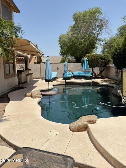 view of swimming pool featuring area for grilling and a patio area