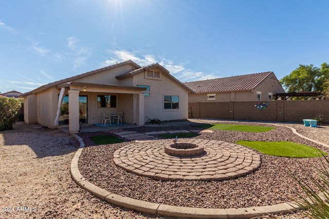 back of house featuring an outdoor fire pit and a patio