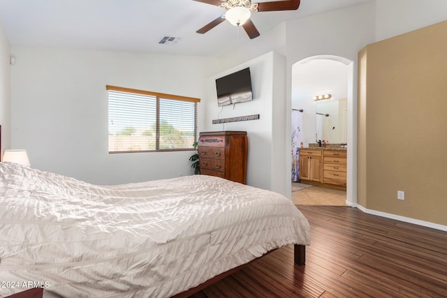 bedroom with ensuite bathroom, light hardwood / wood-style floors, ceiling fan, and vaulted ceiling