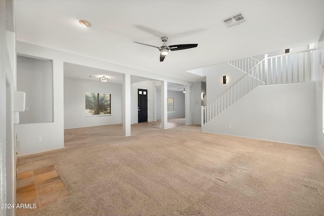 unfurnished living room featuring ceiling fan and light carpet