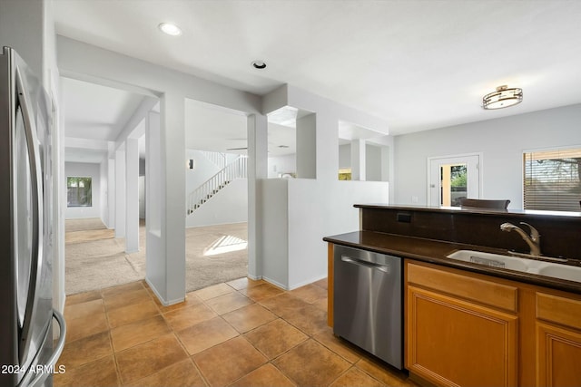 kitchen with sink, appliances with stainless steel finishes, and light carpet