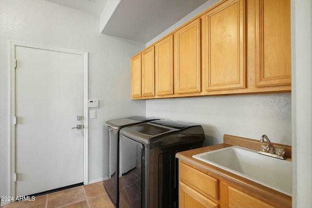 laundry area featuring washer and dryer, light tile patterned floors, cabinets, and sink