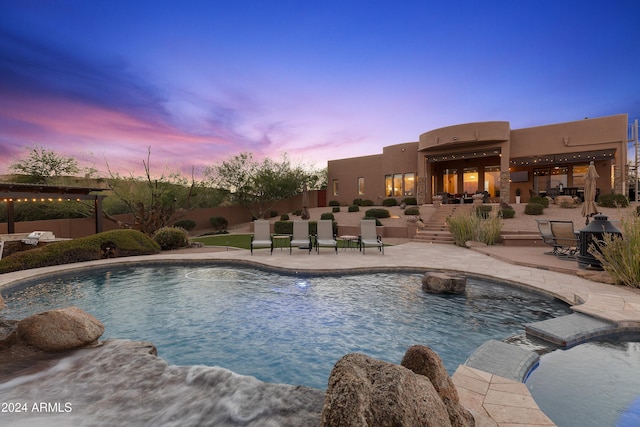 pool at dusk with a patio area