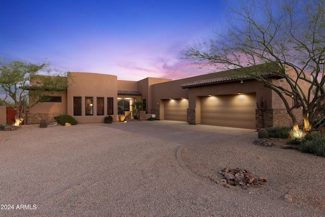 pueblo revival-style home with a garage