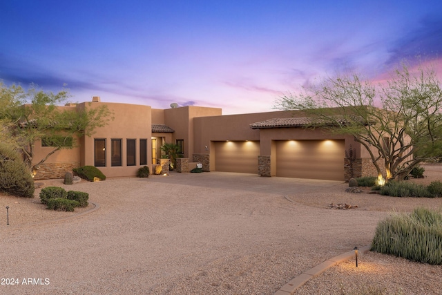 pueblo revival-style home with a garage