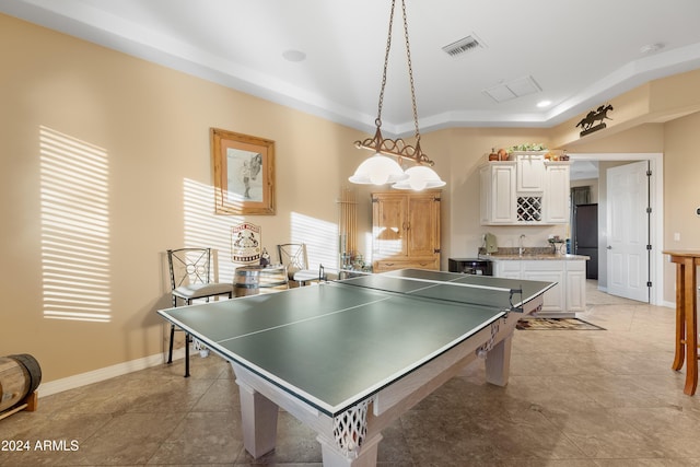 game room with light tile patterned floors, a tray ceiling, and sink